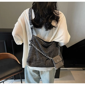 Detail of grey textured tote bag featuring a silver chain and matching mini pouch accessory