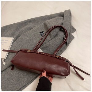 Vue détaillée du sac baguette rétro bordeaux foncé avec boucle et rivets dorés