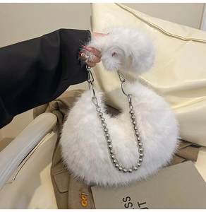 Detail of white faux fur shoulder bag with silver ball chain and elegant metal ring