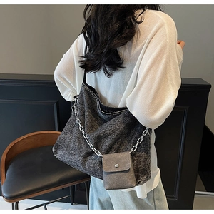 Detail of grey washed denim tote bag with silver chain strap and small pouch