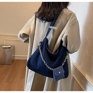 Detail of dark blue denim tote with silver chain and matching mini pouch accessory