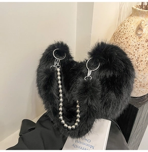 Detail of black fuzzy heart bag with oversized pearl strap and metal ring hardware