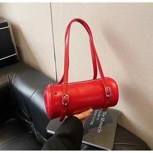 Close-up of a red cylindrical shoulder bag with adjustable straps and silver buckles