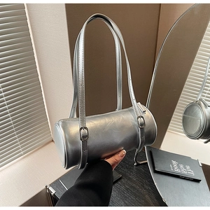 Detail of a silver metallic cylinder bag showing the adjustable strap and zipper closure