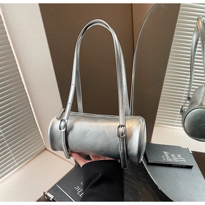 Detail view of silver cylindrical shoulder bag with adjustable strap and metallic finish