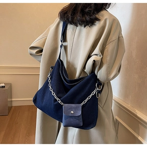 Large denim hobo bag with silver chain and detachable pouch shown on person
