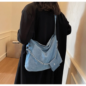 Detail of blue denim tote bag with silver chain and a matching mini coin purse