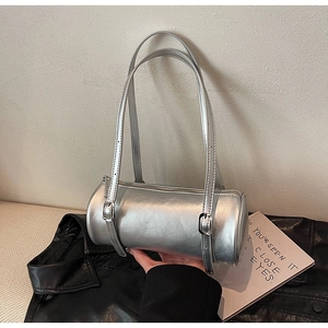 Detailed close-up of a silver cylinder shoulder bag with adjustable thin straps and metallic finish