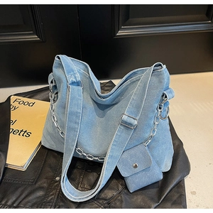 Detail of light blue denim tote with metallic silver chain and matching mini pouch
