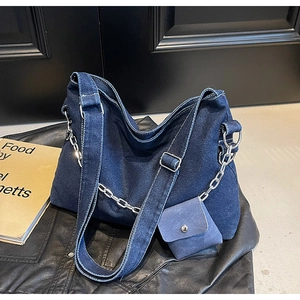 Detail of denim tote bag with silver chain strap and mini coin purse accessory