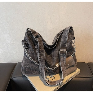 Detail of acid wash denim tote bag featuring silver chain and matching small coin pouch