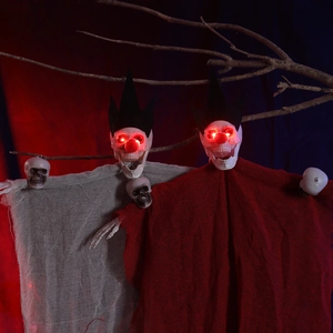 Détail de squelettes d'Halloween avec yeux rouges brillants et capes en gaze usée