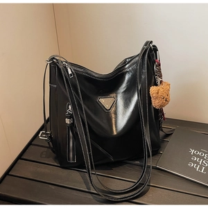 Black PU leather bucket bag with white contrast stitching and brown teddy bear charm