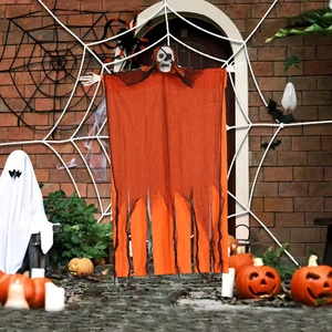 Hanging Halloween skeleton ghost decoration with orange and black mesh on a brick wall