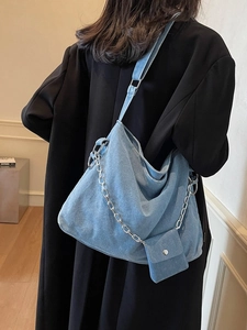 Large denim tote bag in light blue with chain strap and matching small pouch