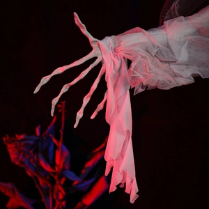 Detailed view of skeleton hand with tattered white gauze in red and blue ambient lighting