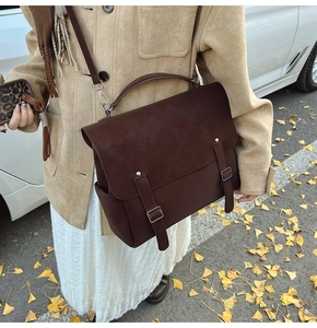 Outdoor street style view of a dark brown matte backpack with metal buckle closure