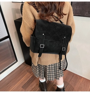 Detail view of a black frosted vintage backpack with silver buckles on a female model