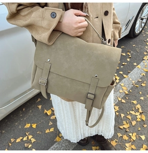 Outdoor shot of a vintage large messenger bag held by a model in autumn street setting
