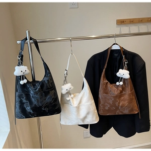Detail view of large Hobo tote bags with marble texture and plush cloud charms