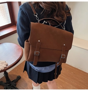 Detail view of brown vintage satchel backpack with matte finish and buckle straps