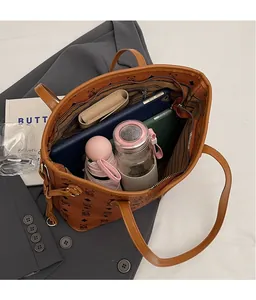 Top view of spacious brown tote bag interior with multiple daily essentials and zipper pocket