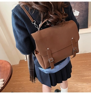Detailed view of brown vintage backpack with double buckle straps and silver hardware