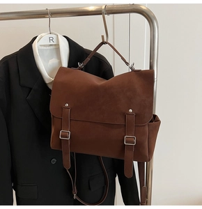 Detail of retro brown frosted tote bag with metal buckles and matte leather finish
