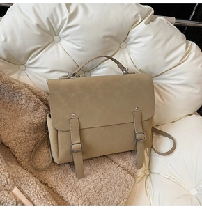 Detail of khaki frosted leather backpack with twin vertical straps on soft textures