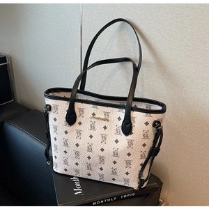 Close-up of white lychee texture tote bag with black bear print and golden metal logo