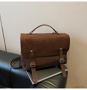 Detail shot of a brown frosted leather backpack with dual straps and retro metal buckles