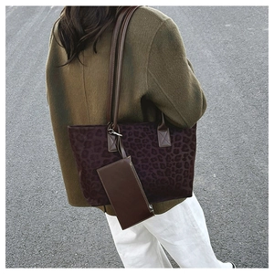 Outdoor view of a large purple leopard print suede tote bag with matching pouch