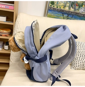 Detail view of the wide padded shoulder straps and breathable mesh on the blue backpack