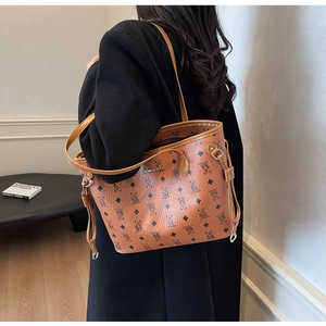 Brown tote bag with bear pattern and metal logo shown on model for size perspective