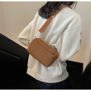 Detailed back view of a brown canvas crossbody bag with adjustable wide strap