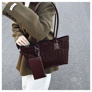 Detail of leopard print suede tote bag set with matching small pouch in street style