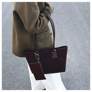 Street style view of a burgundy leopard print suede tote bag with a small side pouch