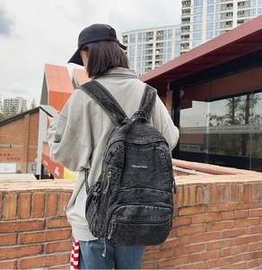 Detalle de mochila en mezclilla gris oscuro con bordado blanco 7street Giane
