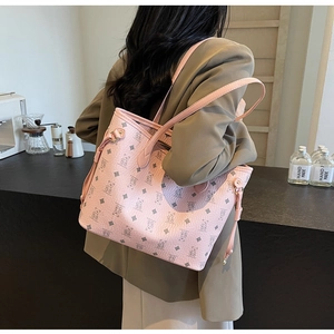 Detailed view of pink tote bag with bear print and side drawstrings shown on model