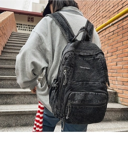 Vista trasera de la mochila de mezclilla lavada con bordado en una escalera de ladrillo