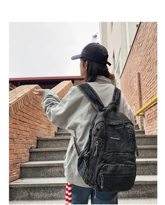 Vista trasera exterior de una mochila de mezclilla negra lavada con bordado 7street Jeans