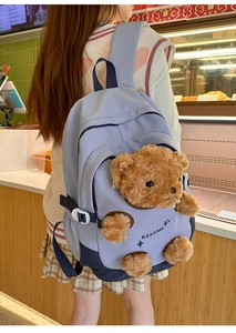 Detail of blue canvas school backpack with cute 3D brown teddy bear decoration