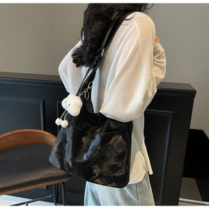 Glossy black tote bag for women with a cute white plush cat charm accessory detail