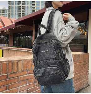 Vista lateral de la mochila de mezclilla gris con texto Petreet Blue en un modelo