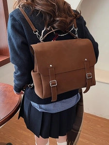Brown matte retro backpack with dual buckle straps shown from a back-view model perspective