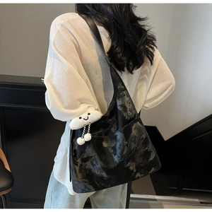 Detailed back view of a large black marble print hobo tote bag with white cloud charm