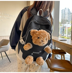 Close-up of black nylon backpack featuring a cute brown 3D plush teddy bear detail
