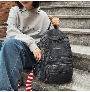 Detalle de la mochila de mezclilla lavada con bordado 7street Glane y bolsillos