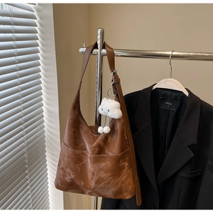 Close-up of brown tote bag with marble texture and a cute white cloud pendant