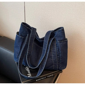 Détails du sac fourre-tout en denim bleu foncé avec poches latérales et anses solides